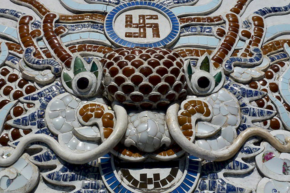 The ceramic mosaic mural of a dragon and the swastika symbol stands out with deep Buddhist symbolism